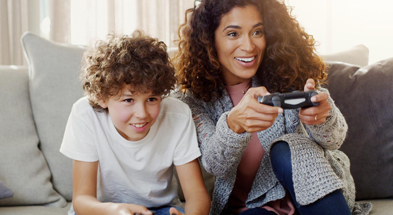 Mother and son playing video games with their consoles.